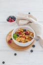 Bowl for breakfast with tiny pancake cereal with blueberries, raspberries, mint