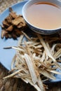 Bowl of brewed chinese herbs with dried assorted roots aside.