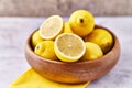 Bowl of bunch of lemons and halves on a marble surface Royalty Free Stock Photo