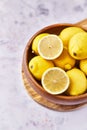 Bowl of bunch of lemons and halves on a marble surface Royalty Free Stock Photo