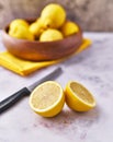 Bowl of bunch of lemons and halves on a marble surface Royalty Free Stock Photo
