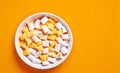 Bowl of candy corn on an orange background with space for copy view from top of table