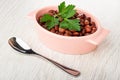 Bowl with canned red beans and parsley, spoon on wooden table Royalty Free Stock Photo