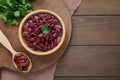 Bowl of canned red kidney beans, parsley and spoon on wooden table, flat lay. Space for text Royalty Free Stock Photo