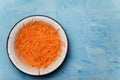 Bowl of carrots cut into thin strips on blue painted wooden background. Vegetarian, organic, healthy food, diet, nutrition. Top