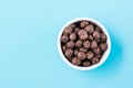A bowl with cereal chocolate balls dry breakfast on a light blue background. Top view Royalty Free Stock Photo