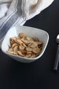 Bowl of cereal, cornflakes with milk in a bowl on a black background