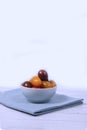 A bowl of Cherry-tomatoes on blue napkin isolated on white wooden background. Vertical image Royalty Free Stock Photo