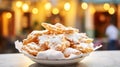 Bowl of chiacchiere against an evening cityscape. Chiacchiere ready to be savored on a city backdrop, a bite of carnival amidst