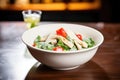 bowl of chicken caesar salad with a focus on a cherry tomato garnish Royalty Free Stock Photo