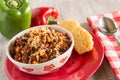 Bowl of Chili With Corn Bread Muffin And Peppers