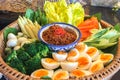 Bowl of Chili Paste with Various Type of Fresh Vegetables and Eggs in Big Rattan Basket