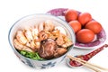 Bowl of Chinese birthday noodle with seafood, meat, red eggs