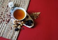 Bowl of chinese herb tea with pieces of astragalus and huang qi roots and jujubes on red background. Top view. Royalty Free Stock Photo