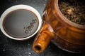 Bowl of Chinese herbal tea and an enamel pot with herbs