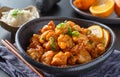 Bowl of chinese orange chicken on table top