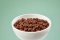 Bowl with chocolate balls. dry breakfast. crunchy corn balls with cocoa on color background. Royalty Free Stock Photo
