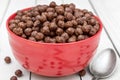 Bowl with chocolate cereal balls and spoon on white wooden table. Close up Royalty Free Stock Photo