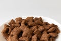 Bowl with chocolate corn pads isolated on white background, cereals breakfast Royalty Free Stock Photo