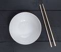 Bowl with chopsticks on a black wooden bird's eye view Royalty Free Stock Photo