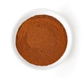 Bowl of cinnamon powder isolated on white, from above Royalty Free Stock Photo