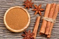 Bowl with cinnamon powder and sticks with anise star on table Royalty Free Stock Photo