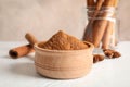 Bowl with cinnamon powder, cinnamon sticks and anise on white background Royalty Free Stock Photo