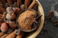 Bowl with cinnamon sticks, powder, sugar and hazelnuts on table, closeup Royalty Free Stock Photo