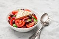 A bowl of classic greek salad with a piece of feta cheese on the table Royalty Free Stock Photo