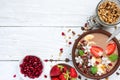 Bowl of cocoa smoothie with chocolate granola, banana, strawberry and pomegranate topped with mint and flowers Royalty Free Stock Photo