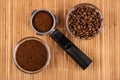 Bowl with coffee beans, holder from coffee maker with ground coffee, bowl with coffee on mat. Top view Royalty Free Stock Photo