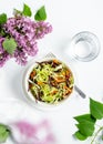 Bowl of coleslaw salad with purple and orange carrots and glass of pure water on white background Royalty Free Stock Photo