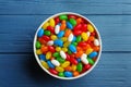 Bowl with colorful jelly beans on blue background, top view Royalty Free Stock Photo