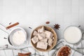 Bowl with compressed yeast, flour and other ingredients on white tiled table, flat lay. Space for text Royalty Free Stock Photo