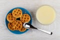Bowl with condensed milk, soft waffles in blue saucer, spoon on table. Top view Royalty Free Stock Photo