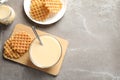 Bowl of condensed milk and waffles served on table, top view with space for text. Dairy products Royalty Free Stock Photo