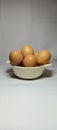 a bowl containing a few chicken eggs on a white background Royalty Free Stock Photo