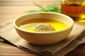 A bowl containing oil, hemp seeds, and marijuana leaves, presented in isolation against a white background, creates a visually Royalty Free Stock Photo