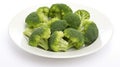 A bowl of cooked green broccoli with sea salt, shot from above on a white plate. Generative AI