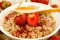 Bowl of cooked oatmeal, berries and strawberry jam