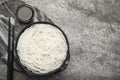 Bowl with cooked rice noodles, soy sauce and chopsticks on grey table, top view. Space for text Royalty Free Stock Photo
