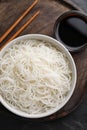 Bowl with cooked rice noodles, soy sauce and chopsticks on table, top view Royalty Free Stock Photo