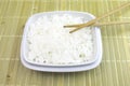 A bowl of cooked white rice with chopsticks on bamboo background Royalty Free Stock Photo