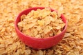 Bowl with corn flakes on corn flakes background Royalty Free Stock Photo