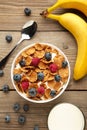 Bowl of corn flakes and fresh berries and fresh fruits on grey Royalty Free Stock Photo