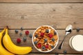 Bowl of corn flakes and fresh berries and fresh fruits on grey wooden background Royalty Free Stock Photo