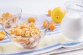 Bowl with corn flakes, jug of milk