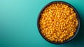 Bowl of corn kernels on turquoise background, top view. Royalty Free Stock Photo