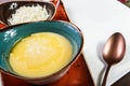 Bowl of corn porridge with butter and cheese on white paper background close up. Royalty Free Stock Photo