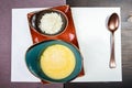 Bowl of corn porridge with butter and cheese on white paper background close up. Royalty Free Stock Photo